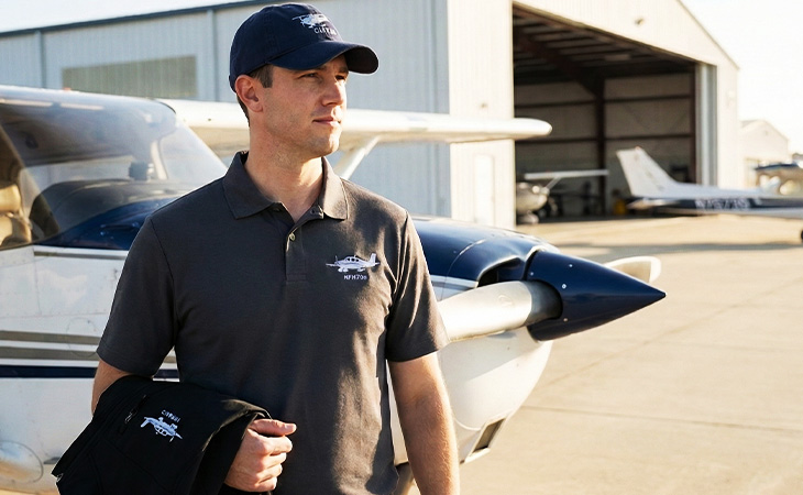 Pilot wearing a custom embroidered baseball cap and polo shirt, everyday aviation apparel