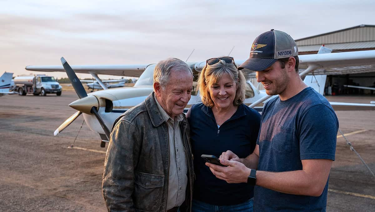 Aviators reviewing tail number gear at small airport with aircraft in background.